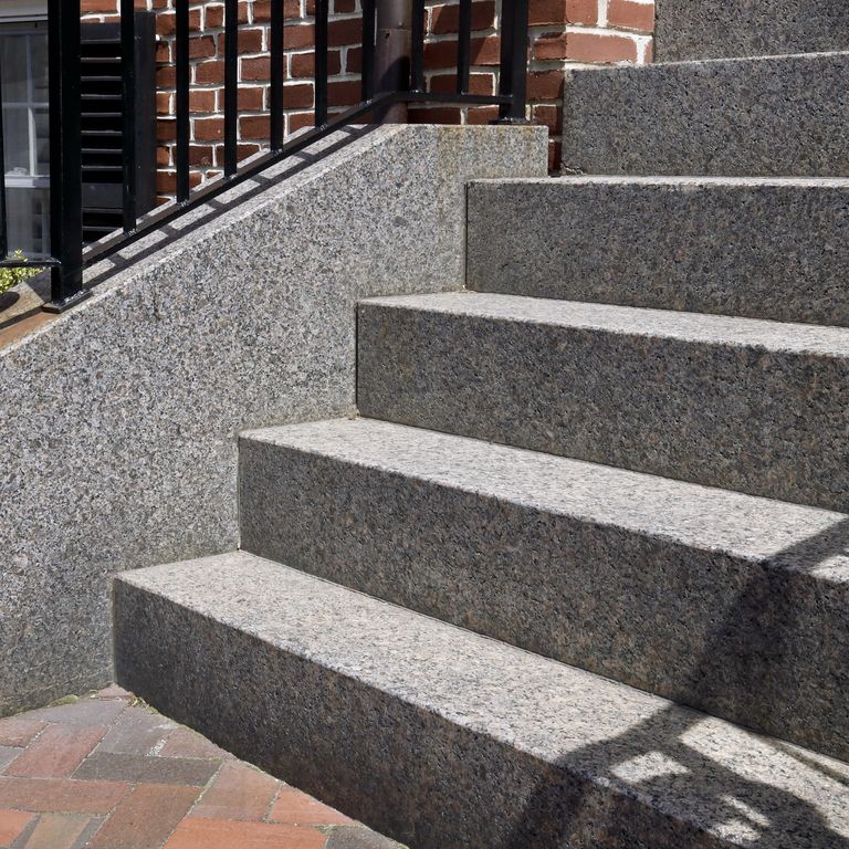 Close-up image for Caledonia Granite - Monolithic Steps. The dominant color shown is gray; with brown, green, purple and white secondaries. The color mix creates a warm feeling. Coarse speckled color pattern. Contains some mica and mineral inclusions.