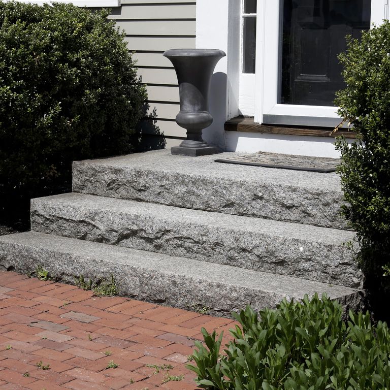 Feature image for Caledonia Granite - Monolithic Steps. The image shows this product being used for landings and monolithic steps. The dominant color shown is gray; with beige, black and white secondaries. The color mix creates a cool feeling. Speckled color pattern. Contains some mica and mineral inclusions.