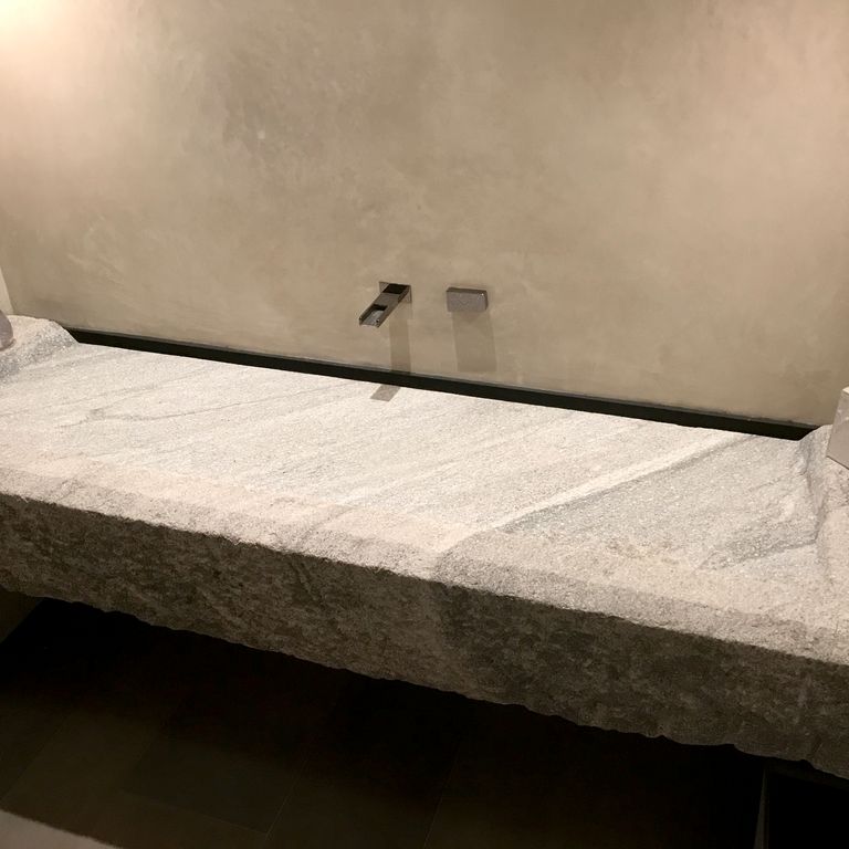 Feature image for Reclaimed Granite Sinks. The image shows this product being used in a sinks application. Dominant colors shown are gray and tan; with brown, orange/rust and cream secondaries. Exhibits 