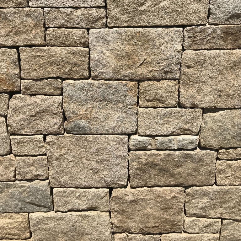 Application image for Cape Neddick Granite Clear - Full Bed Veneer. The image shows this product being used in a landscape wallstone application. The surface finish shown is . The dominant color shown is brown. The color mix creates a warm feeling. Regular color pattern.