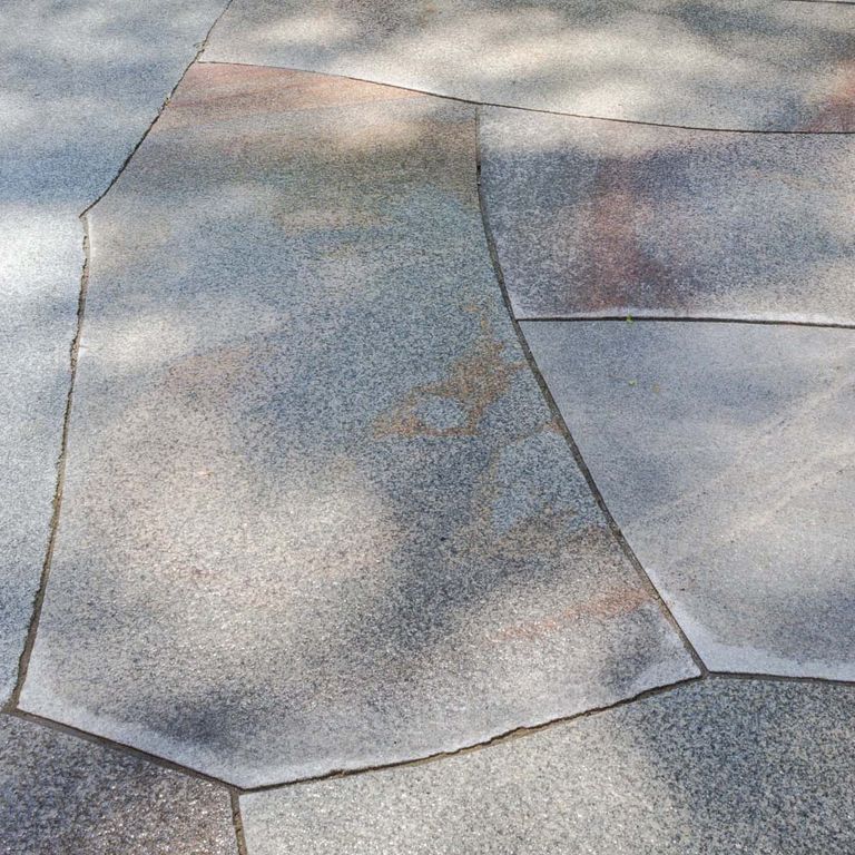 Close-up image for Cape Neddick Granite Full Color - Cut to Fit Pavers. The surface finish shown is flamed. The dominant color shown is gray; with beige, blue, orange/rust, purple and white secondaries. Exhibits 