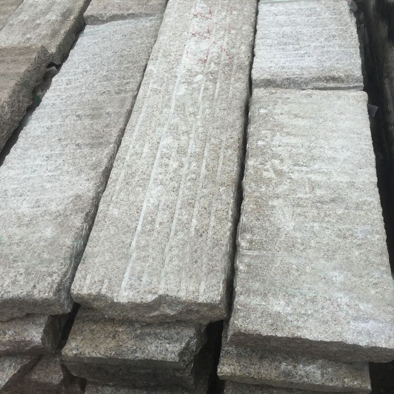 Close-up image for Granite Plank Pavers - Antiqued Surface. The surface finish shown is antiqued. The dominant color shown is gray; with beige and white secondaries. Exhibits 