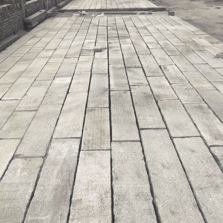 Feature image for Granite Plank Pavers - Antiqued Surface. The image shows this product being used in a patio pavers application. Dominant colors shown are beige and gray; with white and cream secondaries. Exhibits 