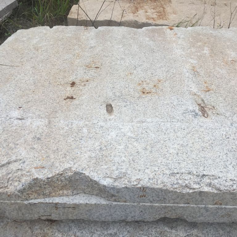 Close-up image for Quarried Chinese Granite - Oversized Quarry Skin Pavers. The surface finish shown is split-face. The dominant color shown is gray; with beige and white secondaries. Speckled and blotched color patterns.