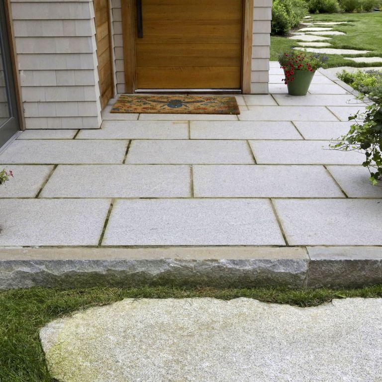 Application image for Cape Neddick Granite Clear - Dimensional Cut Pavers. The image shows this product being used in a patio pavers application. The surface finish shown is a combination of flamed and weathered. The dominant color shown is gray; with beige, white and tan secondaries. The color mix creates a warm feeling. Fine speckled color pattern.