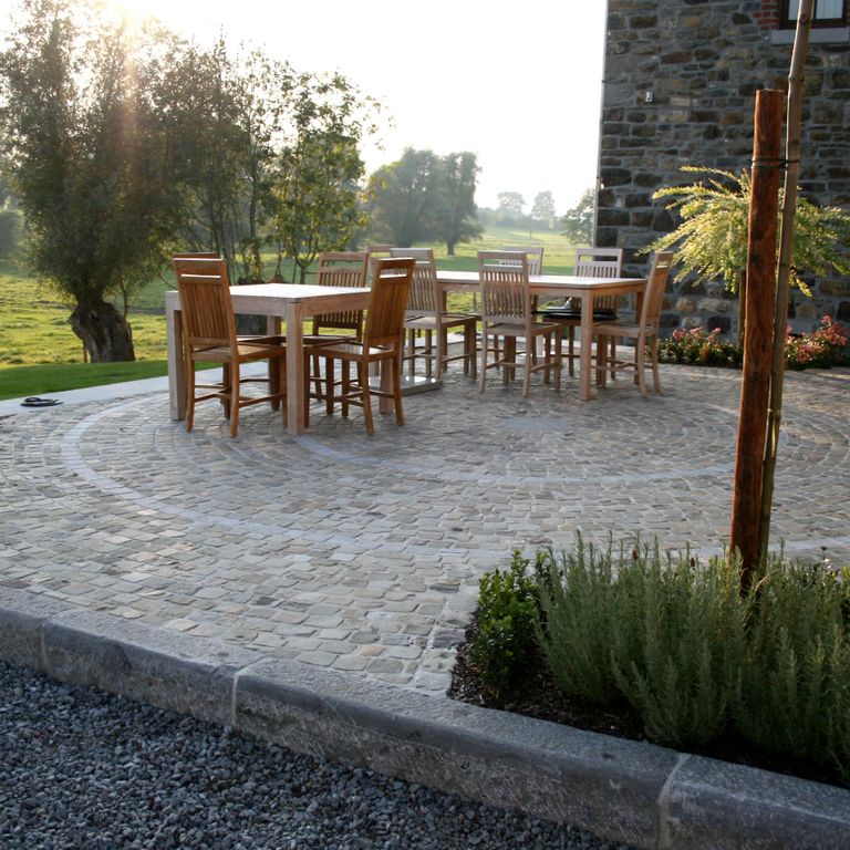 Application image for Reclaimed European Sandstone Cobblestones - Worn Cubes. The image shows this product being used in a patio pavers application. The surface finish shown is . Dominant colors shown are brown and gray. The color mix creates a warm feeling.