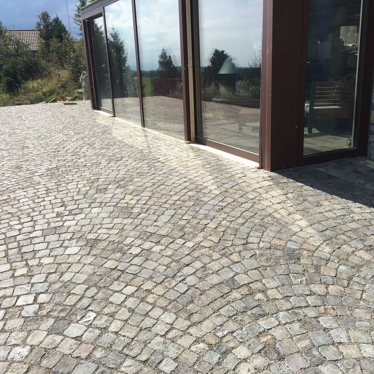 Application image for Reclaimed European Sandstone Cobblestones - Worn Cubes. The image shows this product being used in a path pavers application. The surface finish shown is . The dominant color shown is gray. The color mix creates a cool feeling.