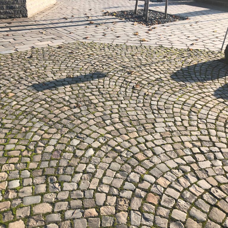 Application image for Reclaimed European Sandstone Cobblestones - Worn Cubes. The image shows this product being used in a patio pavers application. The surface finish shown is . Dominant colors shown are beige, gray and tan. The color mix creates a warm feeling.