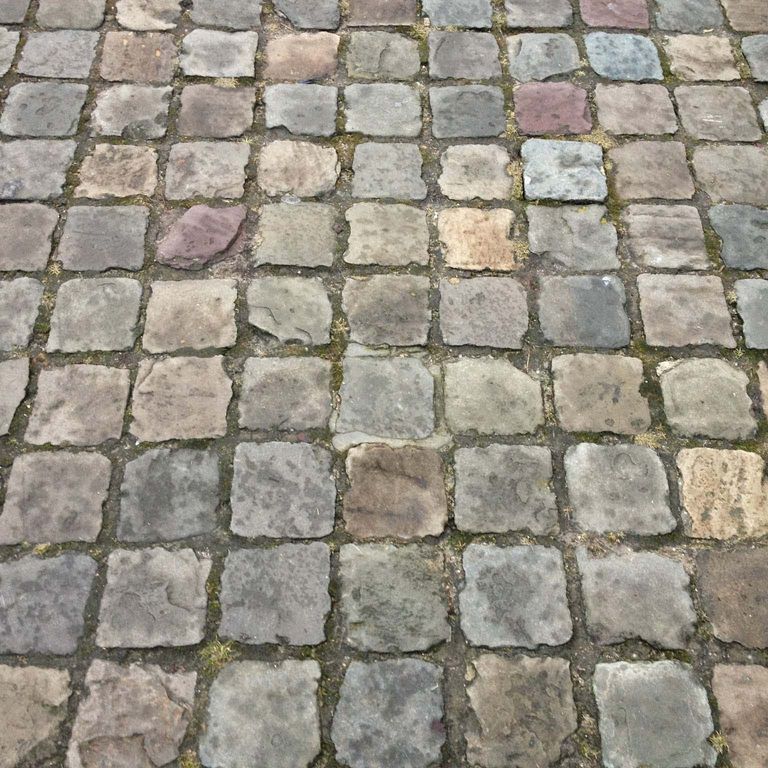 Application image for Reclaimed European Sandstone Cobblestones - Worn Cubes. The image shows this product being used in a patio pavers application. The surface finish shown is . The dominant color shown is gray. The color mix creates a warm feeling.