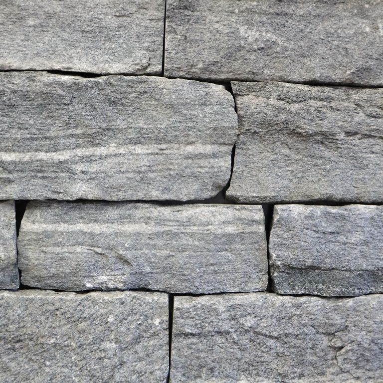 Feature image for Granite - Chester Veneer - End Grain Splitface. The image shows this product being used in a thin veneer application. The surface finish shown is split-face. The dominant color shown is gray. The color mix creates a cool feeling. Regular and linear color patterns.