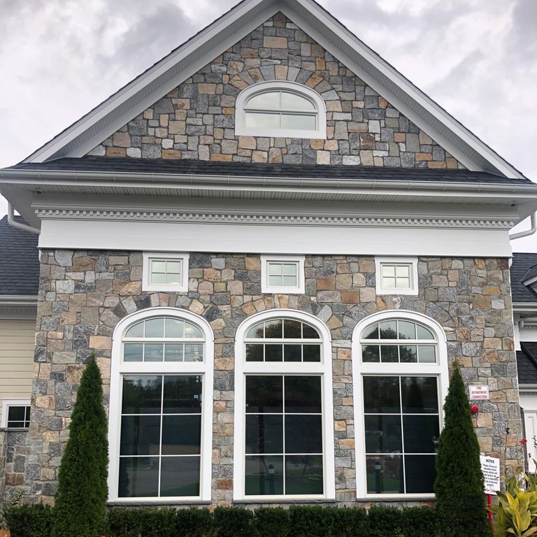 Feature image for Granite - Connecticut Blend - Veneer. The image shows this product being used in a thin veneer application. Dominant colors shown are gray and tan; with black, brown, green, orange/rust, purple, white and cream secondaries. Exhibits 
