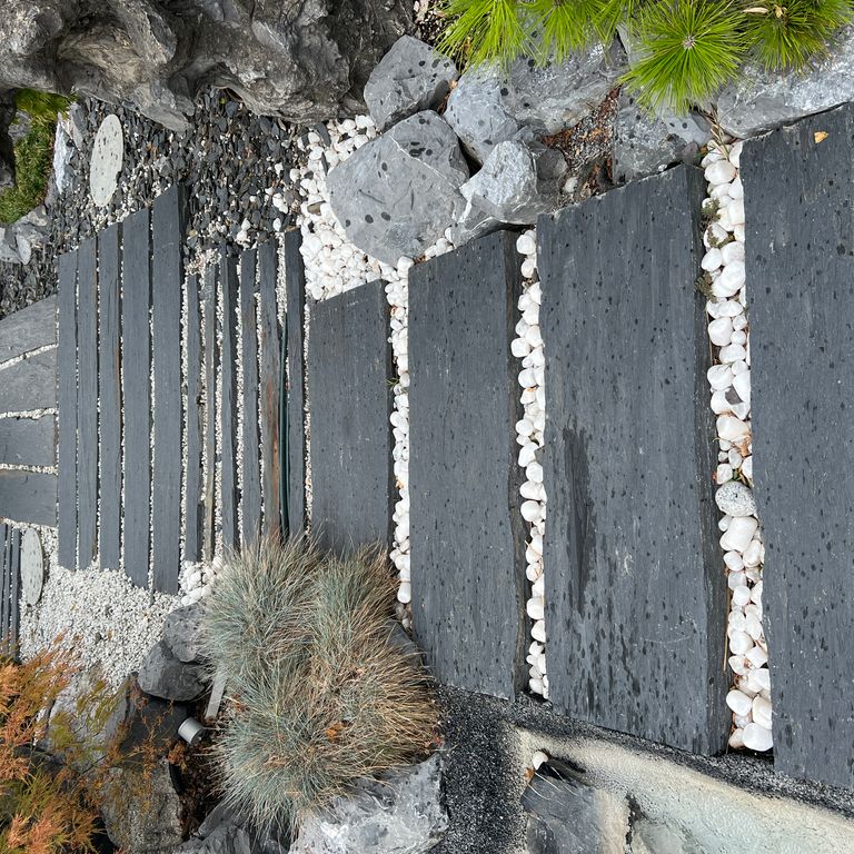 Application image for Black Schist - Pavers. The image shows this product being used in a path pavers application. The surface finish shown is natural cleft. Dominant colors shown are black and gray. The color mix creates a warm feeling.