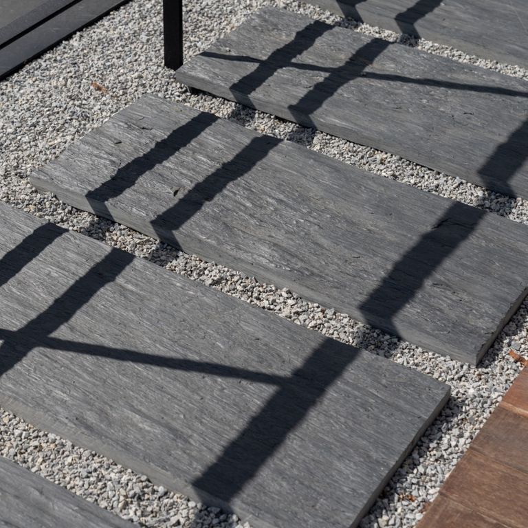 Application image for Black Schist - Pavers. The image shows this product being used in a path pavers application. The surface finish shown is natural cleft. The dominant color shown is gray. The color mix creates a warm feeling.