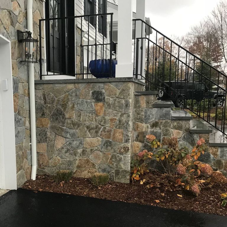 Application image for Spruce Mountain Granite - Veneer. The image shows this product being used for full bed veneer and thin veneer. The surface finish shown is split-face. Dominant colors shown are gray, orange/rust and tan. The color mix creates a warm feeling. Regular and random color patterns.