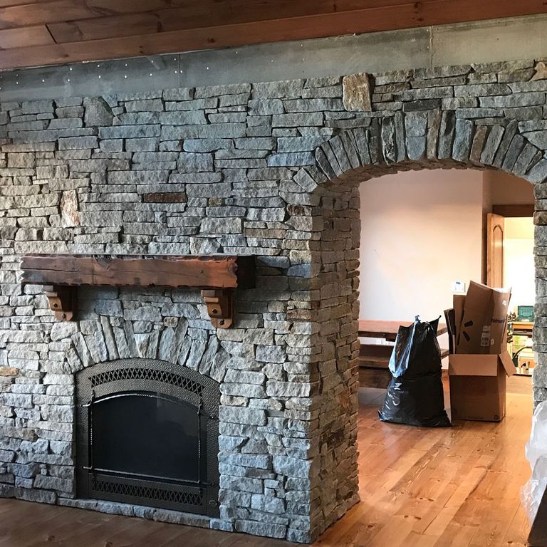 Application image for Granite - Spruce Mountain - Veneer. The image shows this product being used for fireplace surround, full bed veneer, thin veneer and interior cladding. The surface finish shown is split-face. The dominant color shown is gray. The color mix creates a cool feeling. Regular color pattern.
