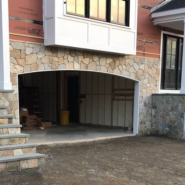 Application image for Spruce Mountain Granite - Veneer. The image shows this product being used for full bed veneer and thin veneer. The surface finish shown is split-face. Dominant colors shown are gray, orange/rust and tan. The color mix creates a warm feeling. Regular and random color patterns.