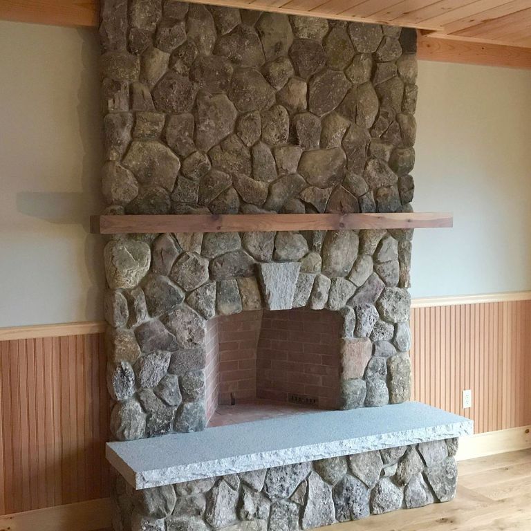Application image for Fieldstone - Old New England Rounds - Thin Veneer. The image shows this product being used for fireplace surround, thin veneer and interior cladding. The surface finish shown is natural. Dominant colors shown are brown, gray and tan. Regular, speckled and random color patterns.