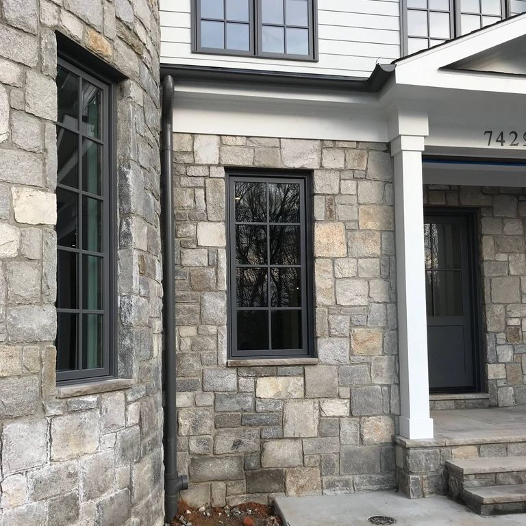 Feature image for Harbor Mist Granite - Wall Veneer. The image shows this product being used for full bed veneer and thin veneer. The dominant color shown is gray; with beige, purple, white, tan and cream secondaries. Exhibits 
