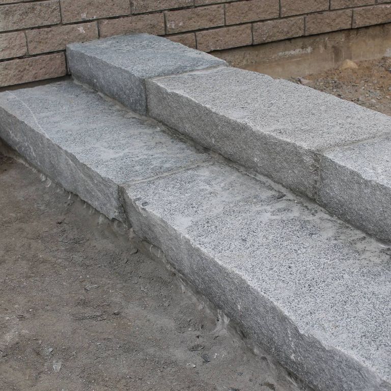 Feature image for Dusty Rose Granite - Monolithic Steps. The image shows this product being used in a monolithic steps application. The dominant color shown is gray; with a white secondary. The color mix creates a cool feeling. Speckled color pattern.