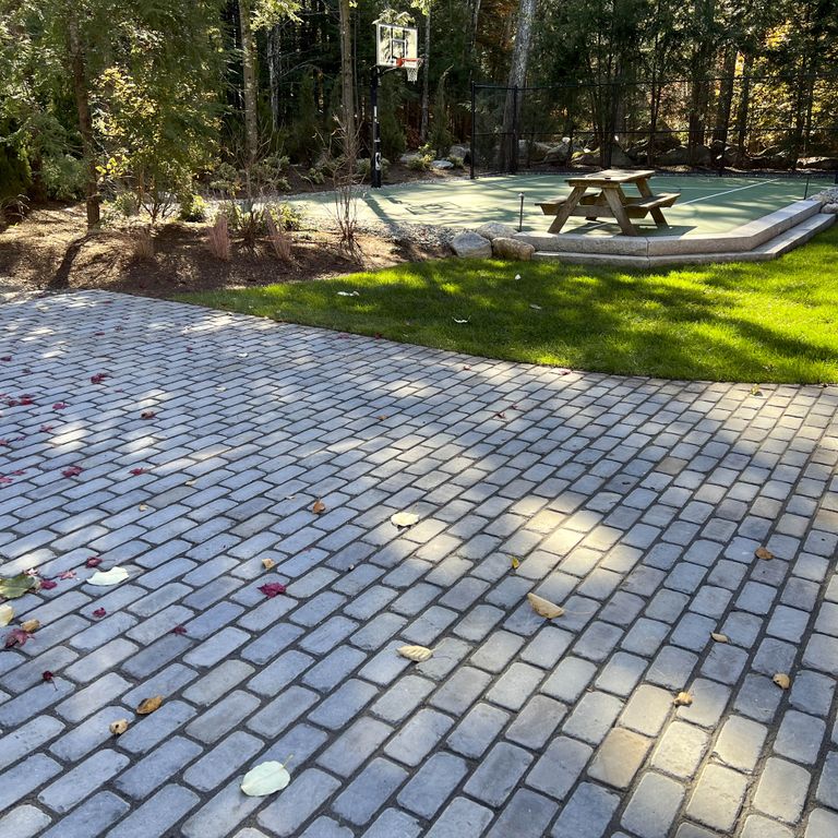 Feature image for Bluestone Blue/Gray - Cobblestone Pavers. The image shows this product being used in a driveway pavers application. The surface finish shown is . Dominant colors shown are blue and gray; with beige and blue secondaries. The color mix creates a cool feeling. Regular color pattern.