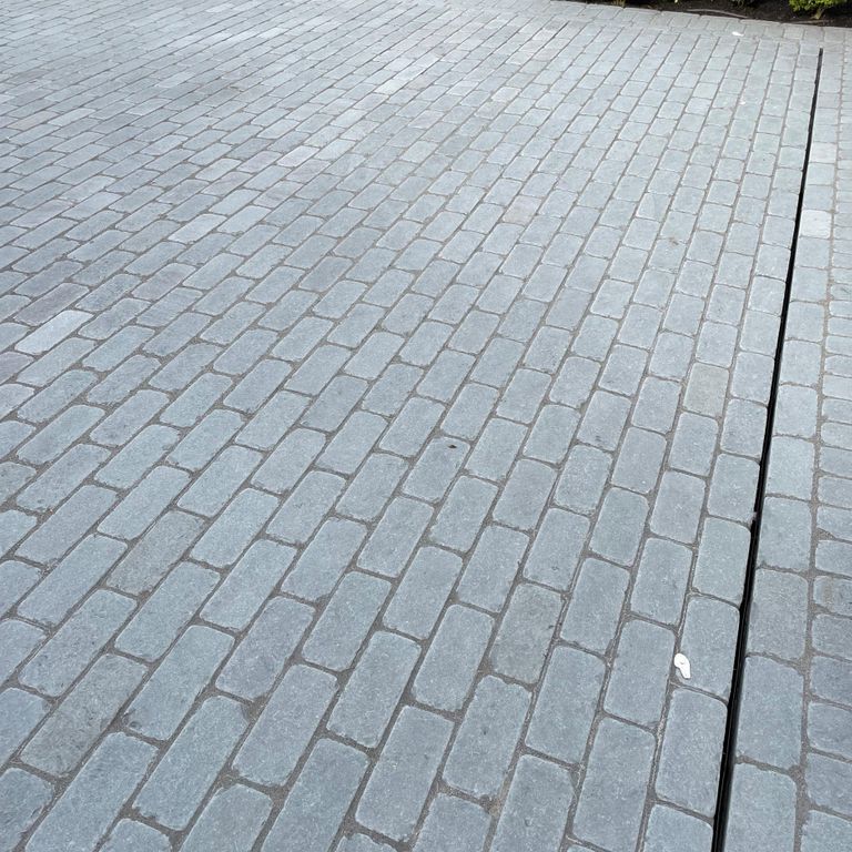 Application image for Bluestone Blue/Gray - Cobblestone Pavers. The image shows this product being used in a driveway pavers application. The surface finish shown is . Dominant colors shown are blue and gray. The color mix creates a cool feeling. Regular color pattern.