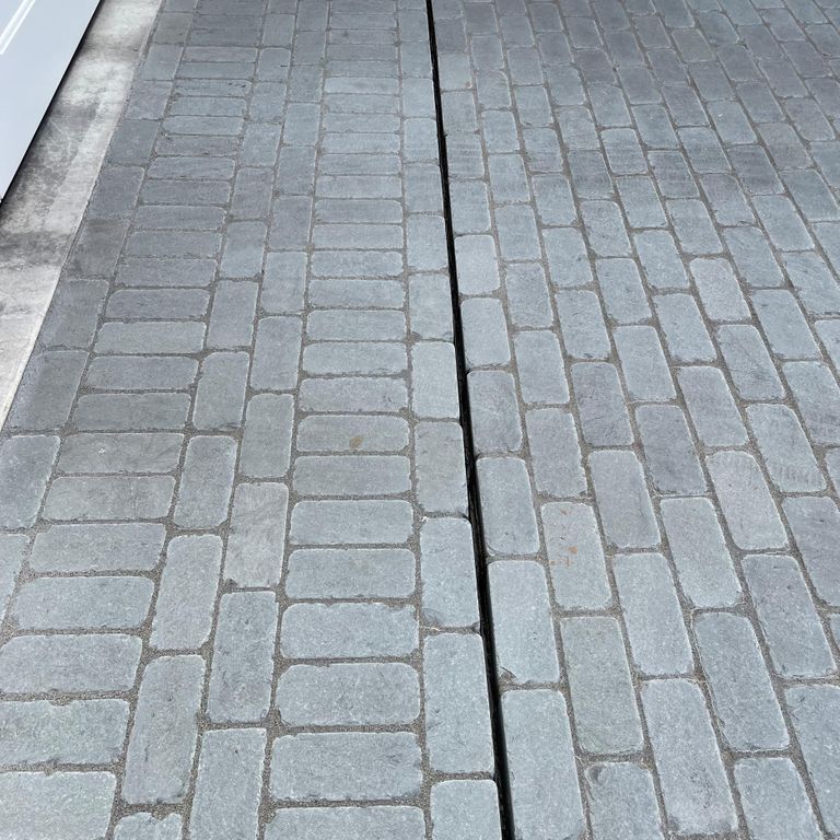 Application image for Bluestone Blue/Gray - Cobblestone Pavers. The image shows this product being used in a driveway pavers application. The surface finish shown is . Dominant colors shown are blue and gray. The color mix creates a cool feeling. Regular color pattern.