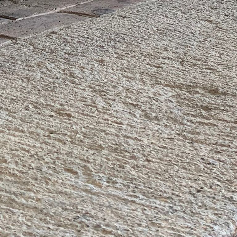 Close-up image for Reclaimed Granite Bridge Blocks - Fireplace Hearth. The surface finishes shown are split-face, weathered and worn. The dominant color shown is gray; with beige and white secondaries. The color mix creates a cool feeling. Speckled color pattern. Contains some mica and mineral inclusions.