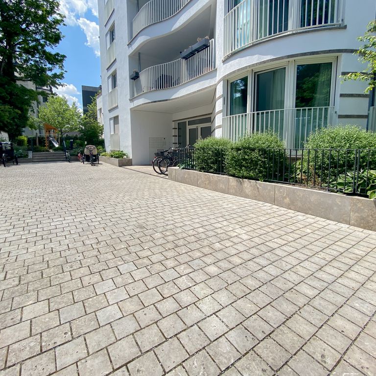 Application image for Bavarian Dolomite Gray Limestone - Cobblestones. The image shows this product being used in a driveway pavers application. Dominant colors shown are beige, gray and tan. The color mix creates a warm feeling.