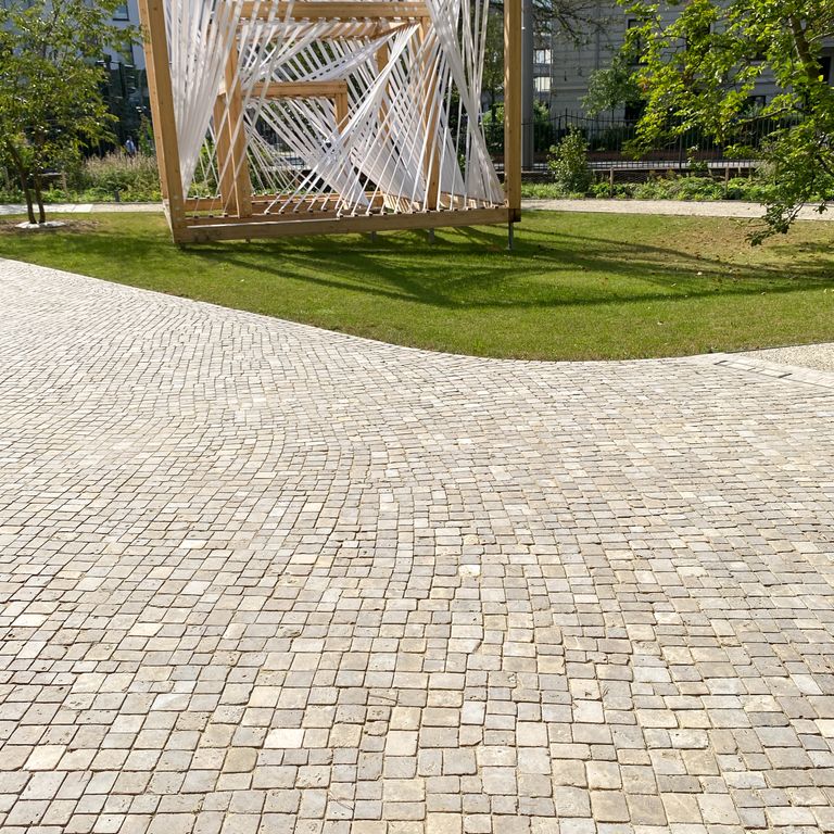 Application image for Bavarian Dolomite Gray Limestone - Cobblestones. The image shows this product being used in a public area application. Dominant colors shown are beige, gray and tan. The color mix creates a warm feeling.