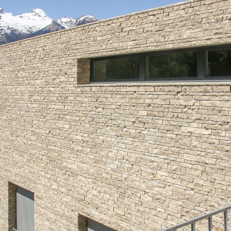 Application image for Bavarian Beige Limestone - Veneer. The image shows this product being used for full bed veneer and thin veneer. The surface finish shown is split-face. Dominant colors shown are beige and tan. The color mix creates a warm feeling.