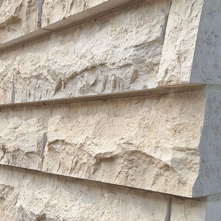 Application image for Bavarian Beige Limestone - Veneer. The image shows this product being used in a full bed veneer application. The surface finish shown is split-face. Dominant colors shown are beige and tan. The color mix creates a warm feeling.