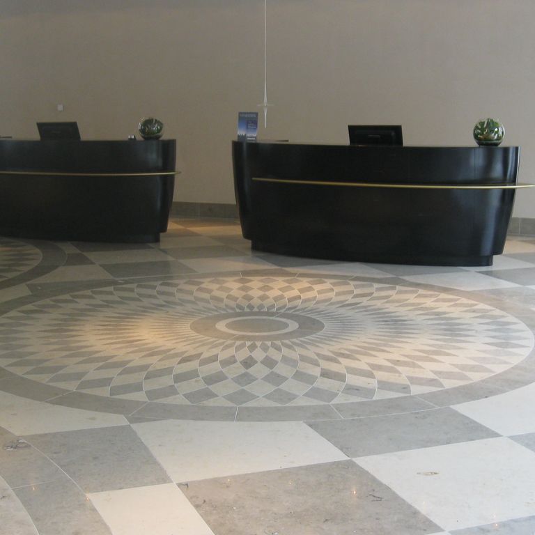 Application image for Bavarian Gray Limestone - Interior Floor. The image shows this product being used in an interior floor application. The dominant color shown is gray; with beige, white and tan secondaries. Exhibits 