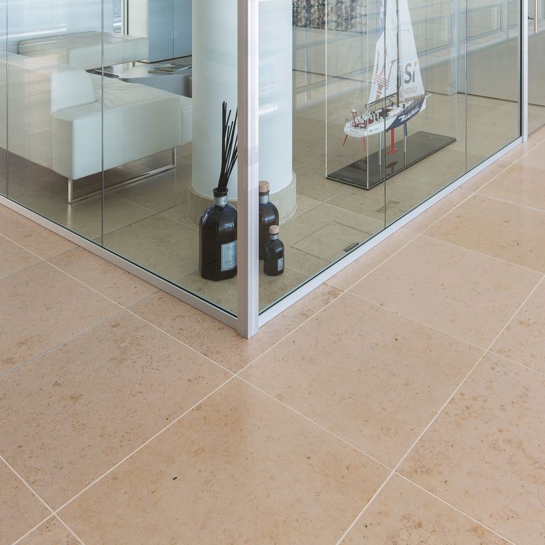 Feature image for Bavarian Limestone Gala - Beige - Interior Floor. The image shows this product being used in an interior floor application. Dominant colors shown are brown and tan; with beige and orange/rust secondaries. Exhibits 