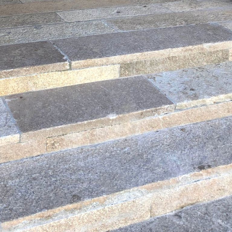 Best close-up image for Reclaimed Footowrn Grantie - Treads. The image shows this product being used in a treads application. The surface finish shown is . The dominant color shown is gray; with beige, brown, orange/rust, white and tan secondaries. Speckled color pattern.