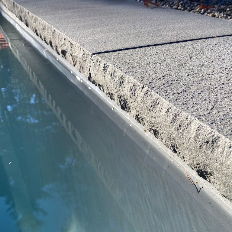 The image shows this product being used for Blue/Gray Bluestone - Flamed Pool Coping.