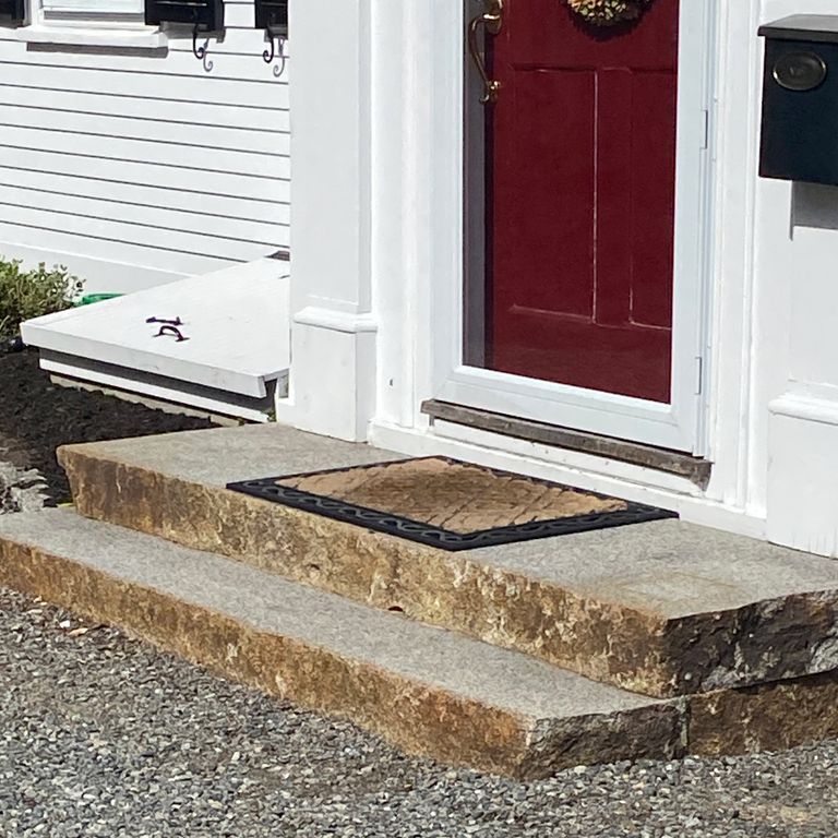 Feature image for Reclaimed Granite Landings - Sawn and Flamed Top, Live Edge. The image shows this product being used for landings and monolithic steps. The dominant color shown is gray; with beige, brown, white, tan and cream secondaries. The color mix creates a warm feeling. Speckled color pattern.