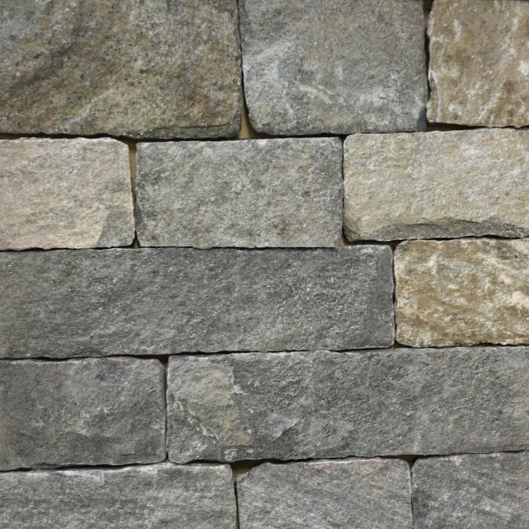 Close-up image for Black Ash Granite - Veneer. The surface finish shown is split-face. Dominant colors shown are green and gray; with brown, orange/rust, purple and tan secondaries. Exhibits 