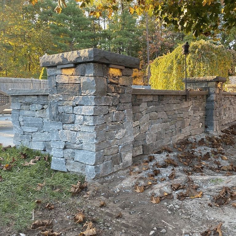 Feature image for Black Ash Granite - Veneer. The image shows this product being used for full bed veneer and thin veneer. Dominant colors shown are blue and gray; with a white secondary. The color mix creates a cool feeling. Regular color pattern.