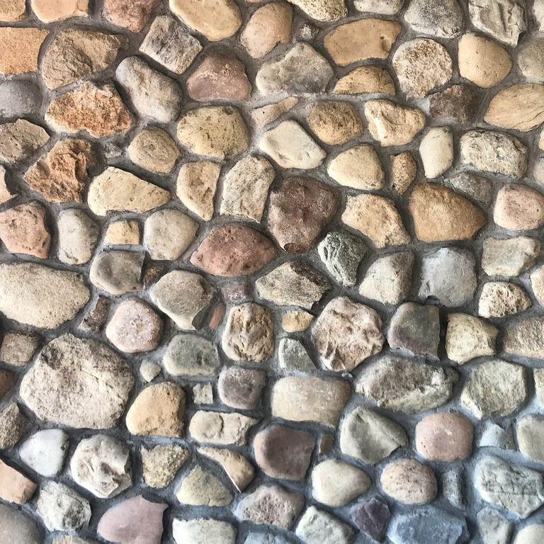 Close-up image for Newport River Rounds - Thin Veneer. The surface finish shown is natural. Dominant colors shown are beige, brown, gray and tan; with orange/rust, purple, white and cream secondaries. Exhibits 