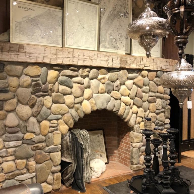 Feature image for River Rounds - Newport - Thin Veneer. The image shows this product being used for fireplace surround, thin veneer and interior cladding. The surface finish shown is natural. Dominant colors shown are beige, brown, gray and tan; with green, orange/rust, purple and cream secondaries. The color mix creates a warm feeling. Regular color pattern.