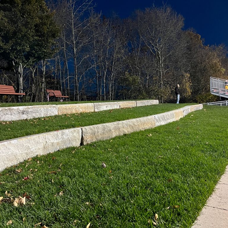 Application image for Reclaimed Third Generation Granite Curbstone - Lawn Steps. The image shows this product being used in a landscape curbing & edging application. The surface finish shown is . Dominant colors shown are beige, tan and cream. The color mix creates a warm feeling. Regular color pattern.