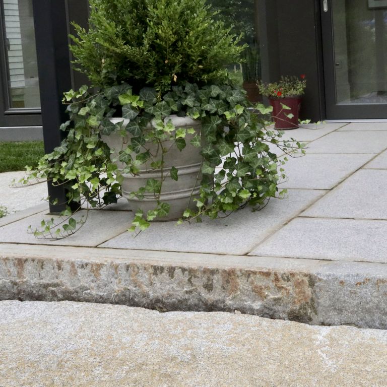 Close-up image for Reclaimed Third Generation Granite Curbstone Edging. The surface finishes shown are sawn, split-face with flat plane, weathered and worn. The dominant color shown is gray; with beige, brown, orange/rust, purple, white, tan and cream secondaries. Exhibits 