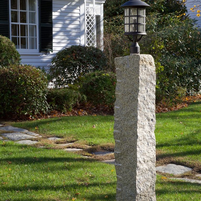 Feature image for Reclaimed First Generation Curbstone - Posts. The image shows this product being used in a posts application. The dominant color shown is gray; with beige, white and tan secondaries. Regular and speckled color patterns.