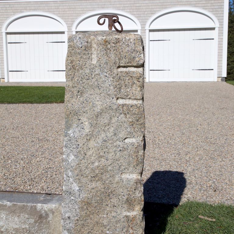 Application image for Reclaimed First Generation Curbstone - Posts. The image shows this product being used in a posts application. The surface finish shown is split-face. The dominant color shown is gray; with beige, brown, orange/rust, purple, white and tan secondaries. Exhibits 