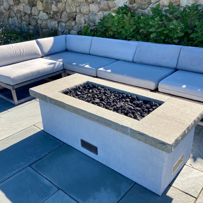 Application image for Bluestone Flamed Surface Blue/Gray Fire Feature. The image shows this product being used in an outdoor fire concepts application. The surface finish shown is flamed. The dominant color shown is gray. The color mix creates a cool feeling. Solid color pattern.