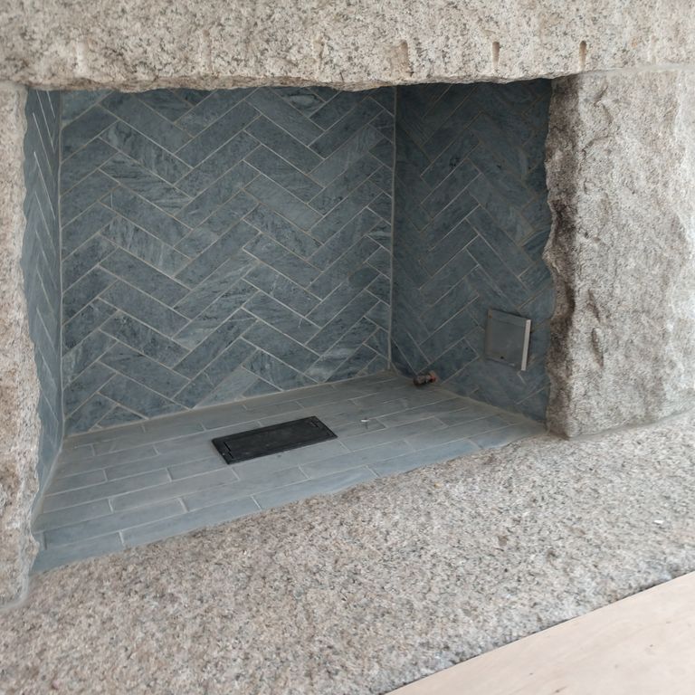 Application image for Mariana Soapstone™ Firebrick. The image shows this product being used in a firebrick application. The surface finish shown is honed. The dominant color shown is gray; with blue and purple secondaries. The color mix creates a cool feeling. Regular color pattern.