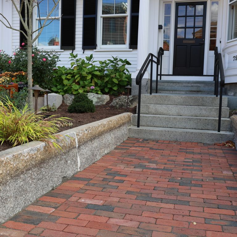 Application image for Granite - Reclaimed Block - Edging. The image shows this product being used in a landscape curbing & edging application. The dominant color shown is gray. The color mix creates a warm feeling.