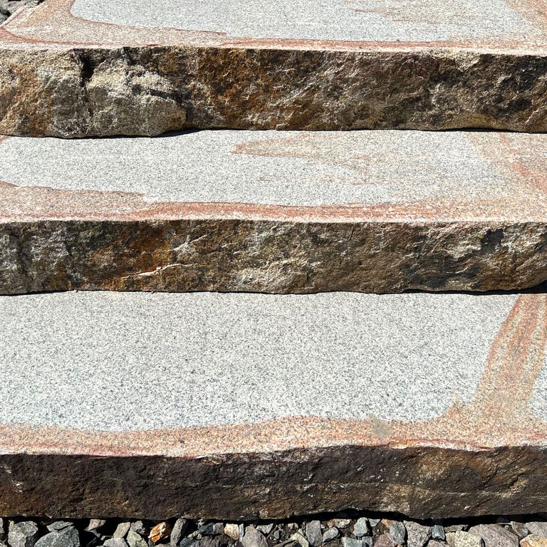 Best close-up image for Granite - Cape Neddick Full Color - Live Edge Steps - Flamed Tops. The surface finish shown is a combination of flamed and natural. The dominant color shown is gray; with beige, black, brown, orange/rust, pink, purple, white, tan and cream secondaries. The color mix creates a warm feeling. Streaked, speckled and blotched color patterns.