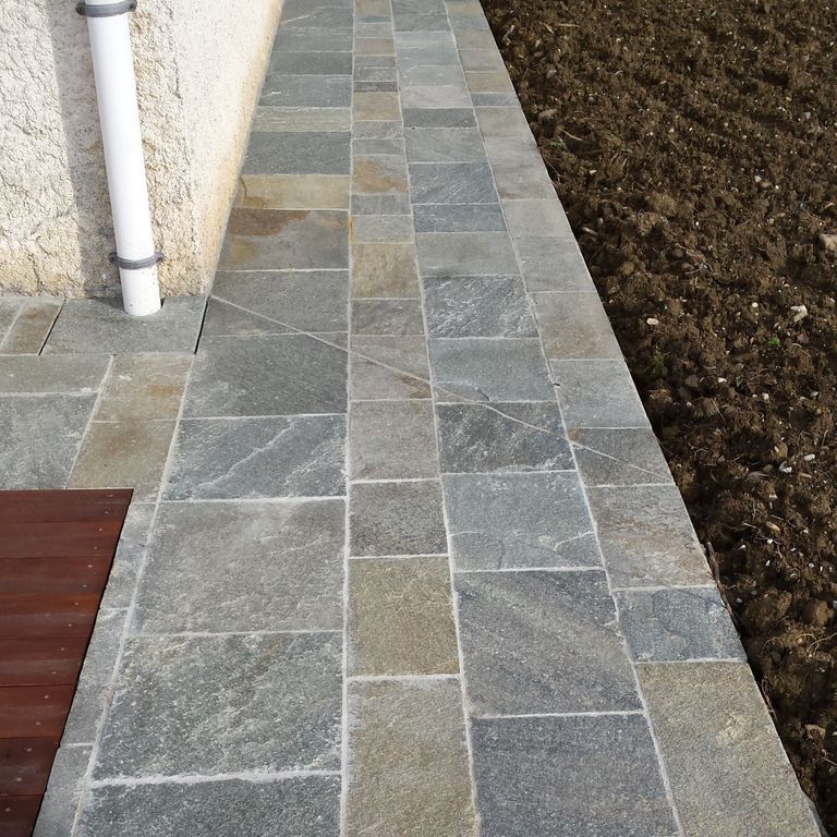 Application image for Pietra Italia Full Color Gneiss - Pavers. The image shows this product being used in a path pavers application. The surface finish shown is natural cleft. Dominant colors shown are gray and tan. The color mix creates a warm feeling.