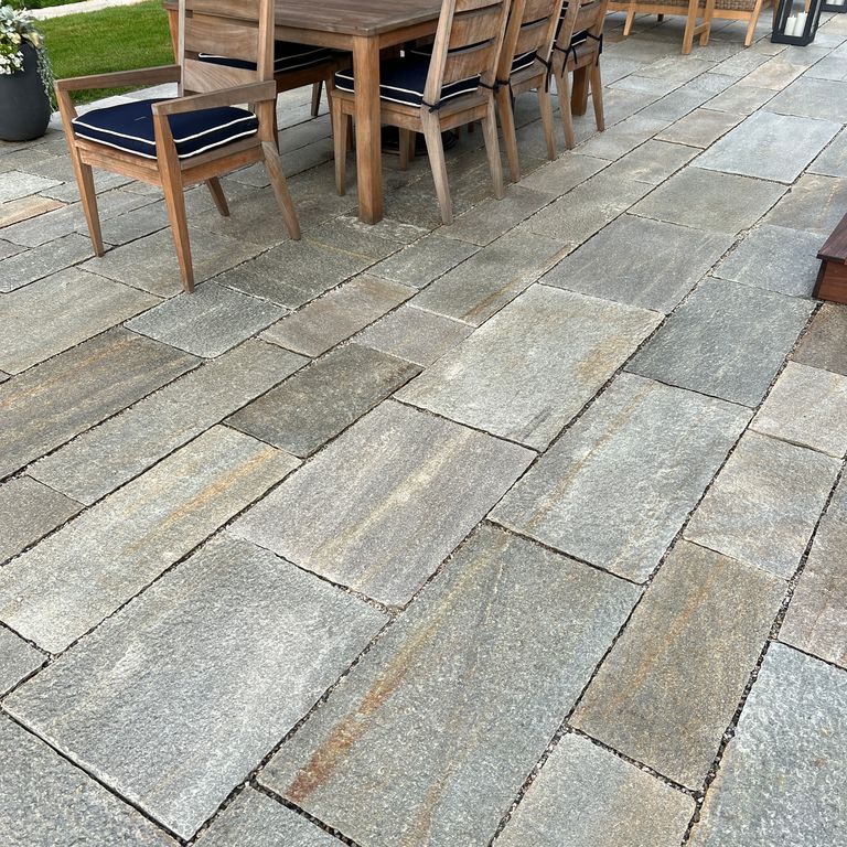 Application image for Pietra Italia Full Color Gneiss - Pavers. The image shows this product being used in a patio pavers application. The surface finish shown is natural cleft. Dominant colors shown are beige and gray. The color mix creates a warm feeling.